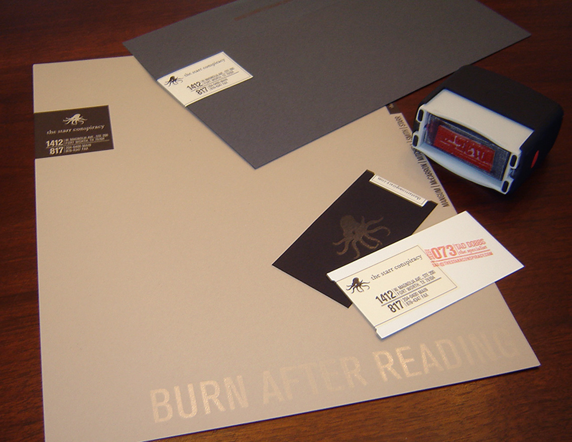 The Starr Conspiracy stationery featuring a dark gray number ten business envelope, letterhead, business card and rubber stamp